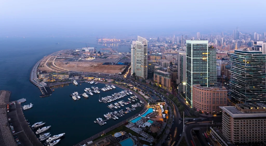 Middle East road trips 2024: An aerial view of Beirut, Lebanon, featuring its picturesque marina, modern skyline, and expansive urban landscape along the Mediterranean coast at twilight.