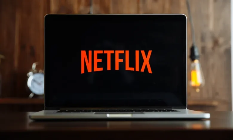 Netflix Shows 2024: A laptop displaying the Netflix logo on its screen, set up in a cozy home environment.